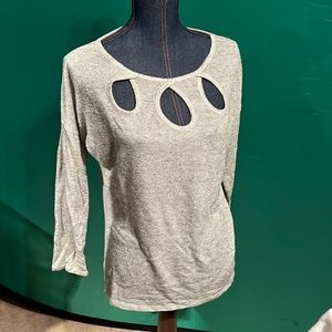 Silver sweater with peek a boo holes in the neckline